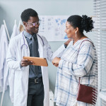 Young African American doctor consulting female patient