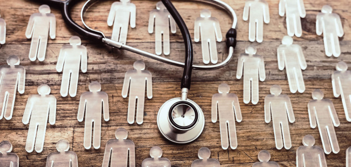 photo illustration figures and stethoscope on wood