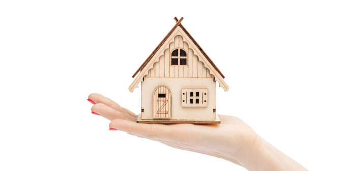 womans hand holding tiny house